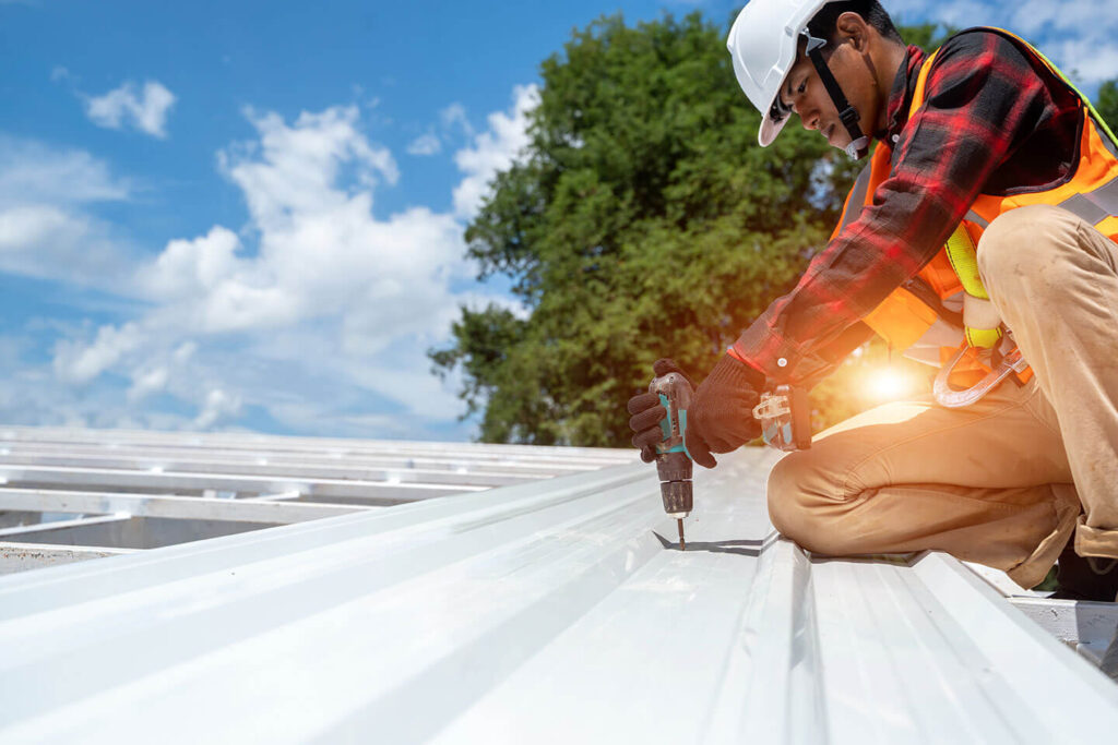 worker performing Kansas city roof repair on metal roof