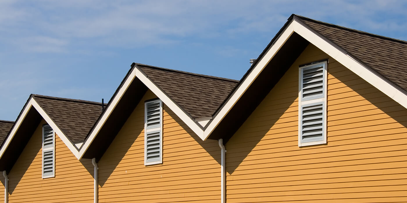 Yellow houses with roofing by Heartland Elite Roofing in Overland Park